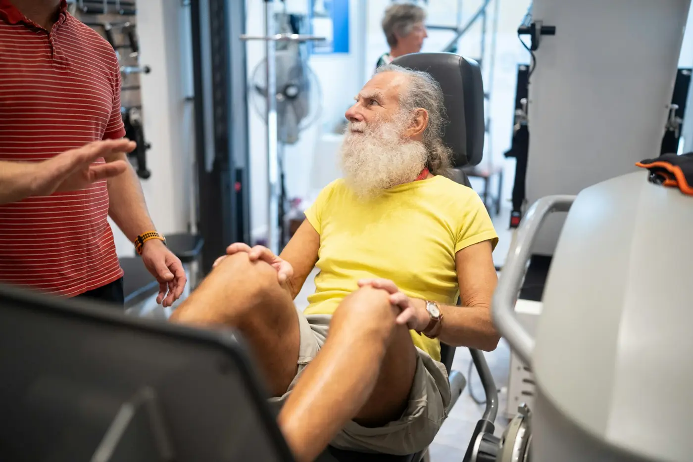 An older man working out on gym equipment during rehab